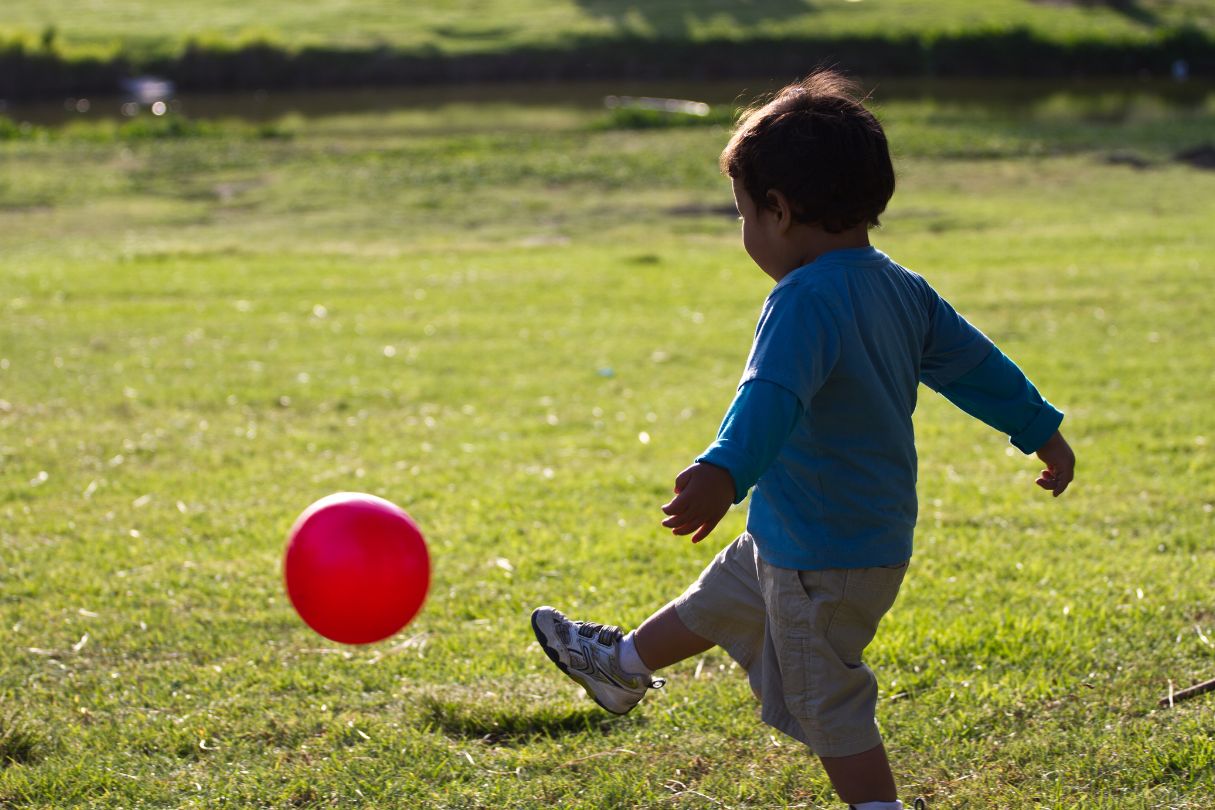 a little boy kicking a soccer ball football