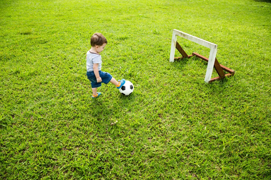 a toddler playing with a football